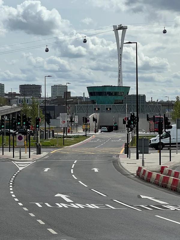 Roadway entering Silvertown Tunnel beneath the cable car, with the northern portal building behind.