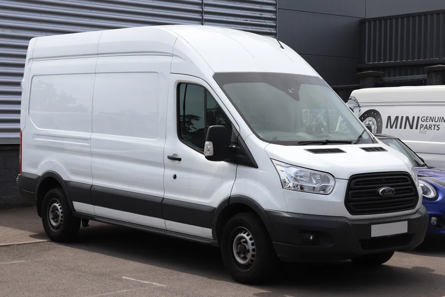 White Ford Transit panel van, showing its enclosed load space and high roof